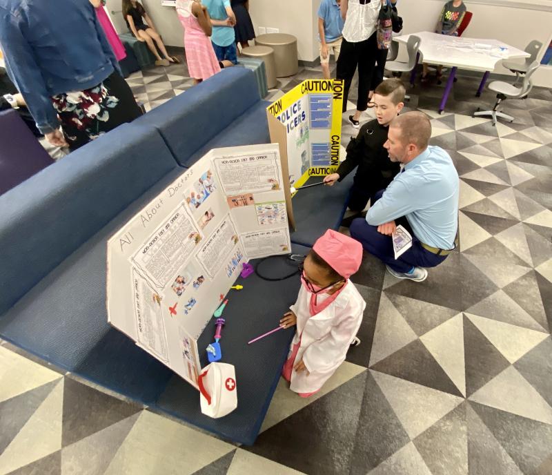 Cape Supervisor of Information Technology Michael League, right, learns about being a police officer from Aiden Veith while Lamiaha Davis has fully embraced the role of a doctor.
